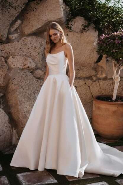 Carmena E259 Abella Carmina E259 by Abella Wedding Dress. Strapless fitted aline plain satin wedding dress with dramatic skirt. Allure Bridals. Available now at Chameleon Bride Bournemouth Dorset