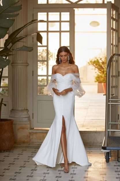 Vicky Milla Nova Wedding Dress. Off shoulder crepe fitted gown with skirt split slit and tulle balloon sleeves