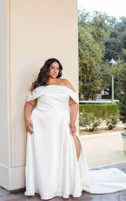Essense of Australia D3631. Mikado satin wedding dress with detachable off shoulder cuff and detachable bow. Can be worn completely strapless for a different 2nd look. Aline skirt with sexy leg split completes the look. UK20 wedding dress. Brides with curves, curvy plus size bride Available to try at Chameleon Bride Bournemouth Dorset