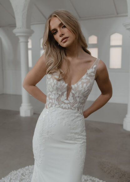 Solace Madi Lane Wedding Dress. Fitted crepe and lace bridal gown with plain skirt and lace insert cage train. Chameleon Bride Bournemouth Dorset